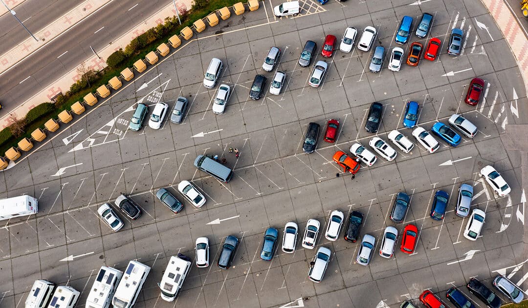 Aerial view of asphalt paved parking lot full of parked vehicles