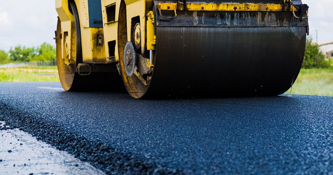 Steamroller flattening out freshly laid asphalt